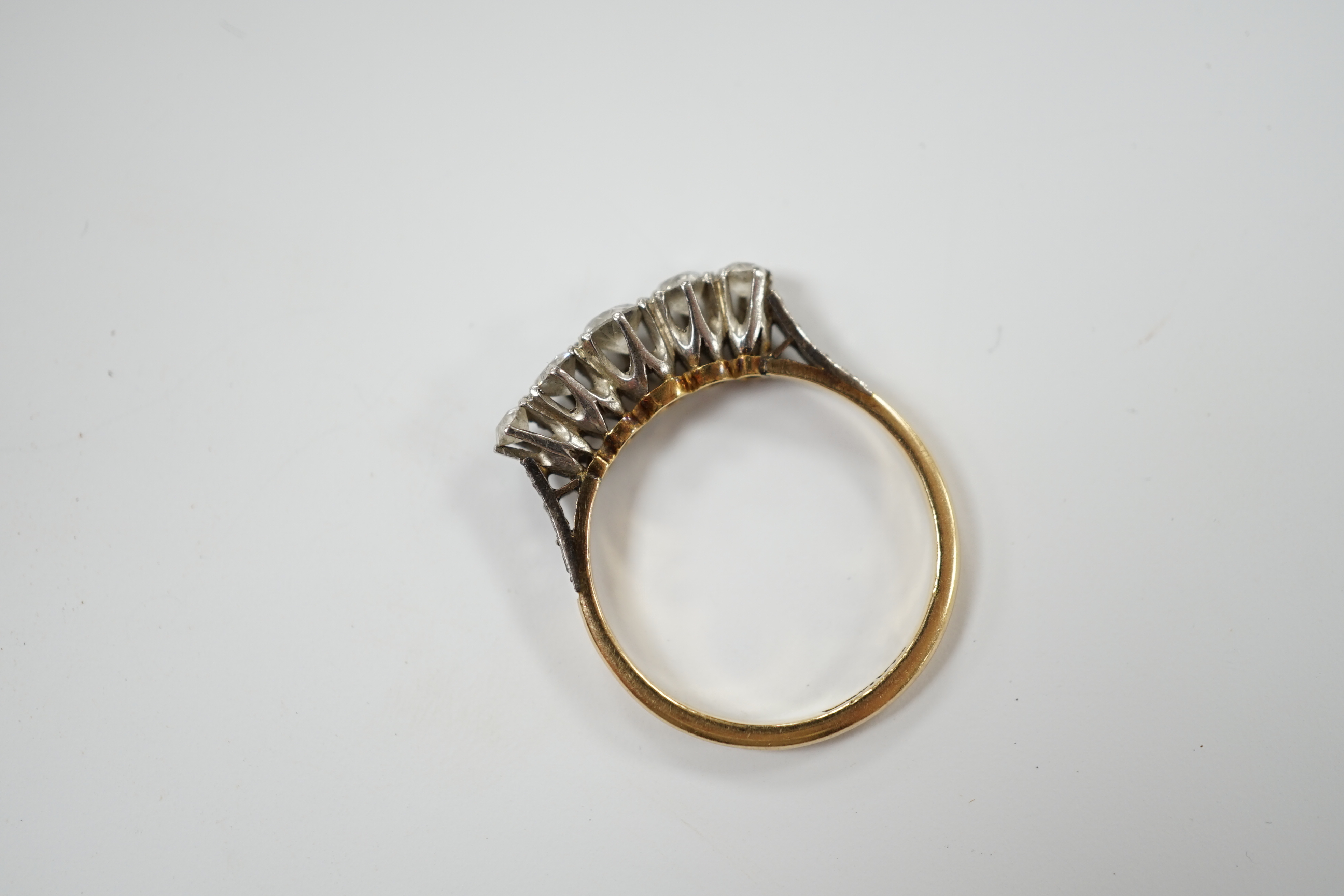 An 18ct, plat. and graduated five stone diamond set half hoop ring, size P, gross weight 3.1 grams.